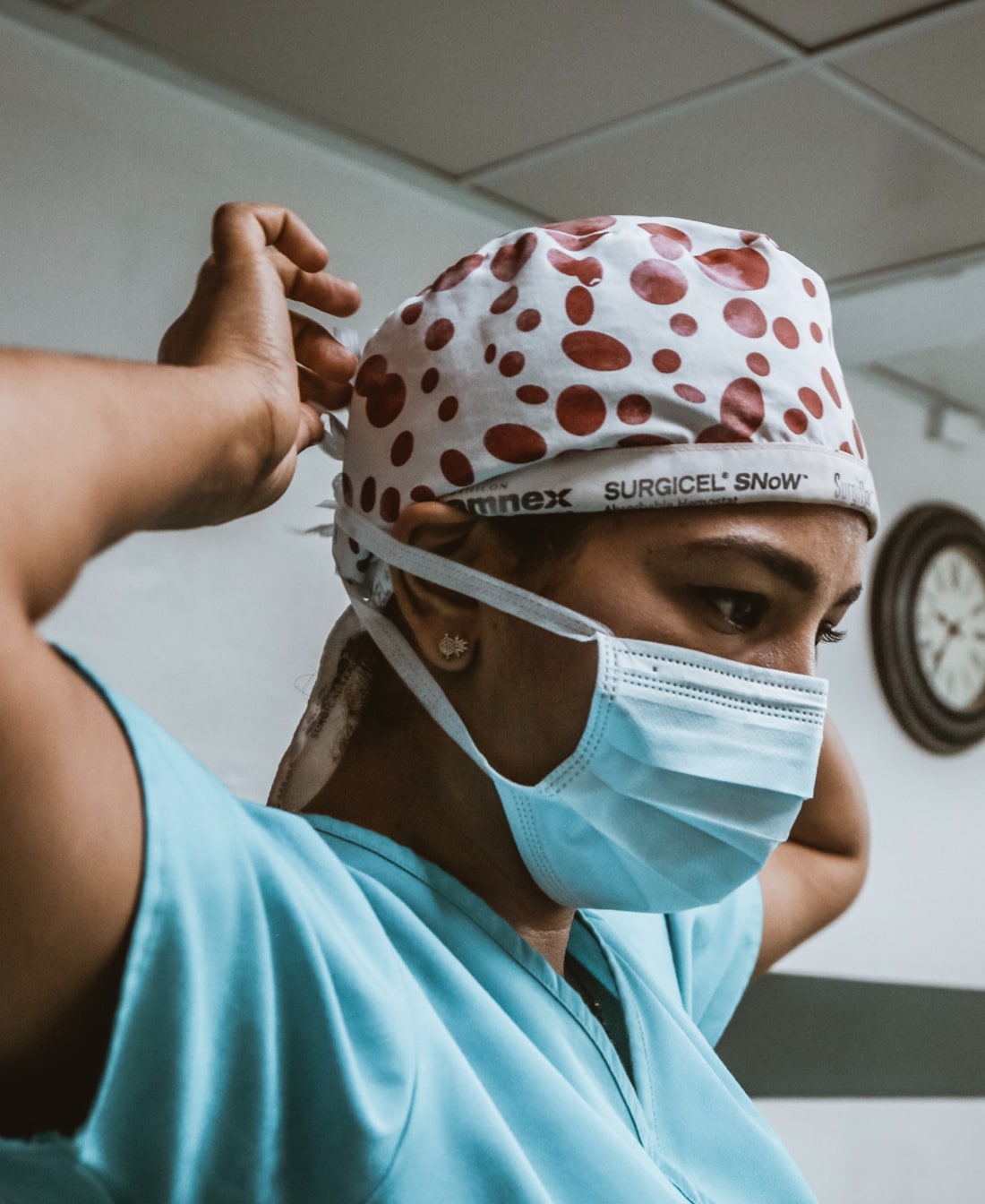 A nurse putting on surgical PPE.